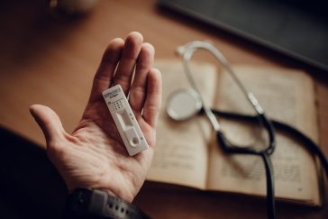 Publicidade médica no Instagram: estetoscópio e dispositivo de teste sobre mesa de consultório, ilustrando a Resolução CFM 2.336/2023